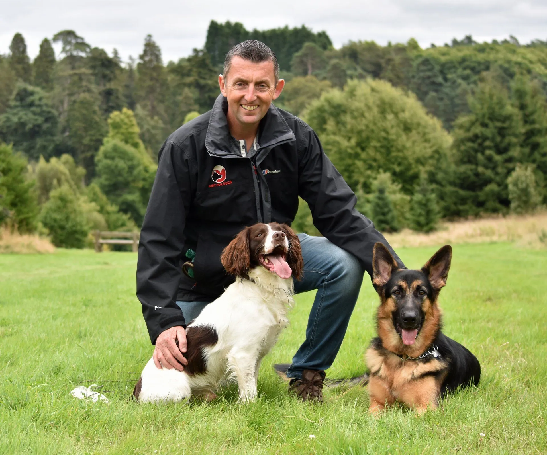 Man with two dogs sitting on grass